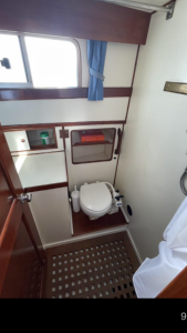 A clean washroom with toilet and hand basin aboard liberty boat charter