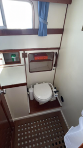 A clean washroom with toilet and hand basin aboard liberty boat charter